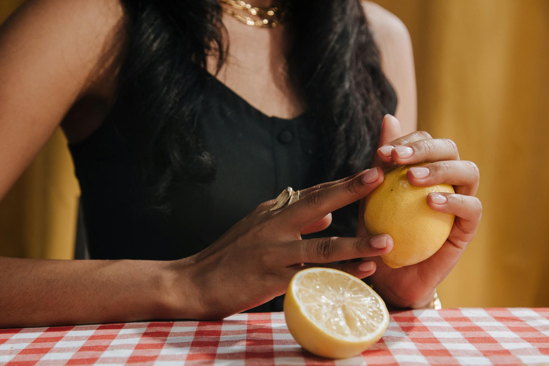 A hand holding an orange vibrator against a minimalistic purple backdrop, showcasing modern sensuality and partnership.