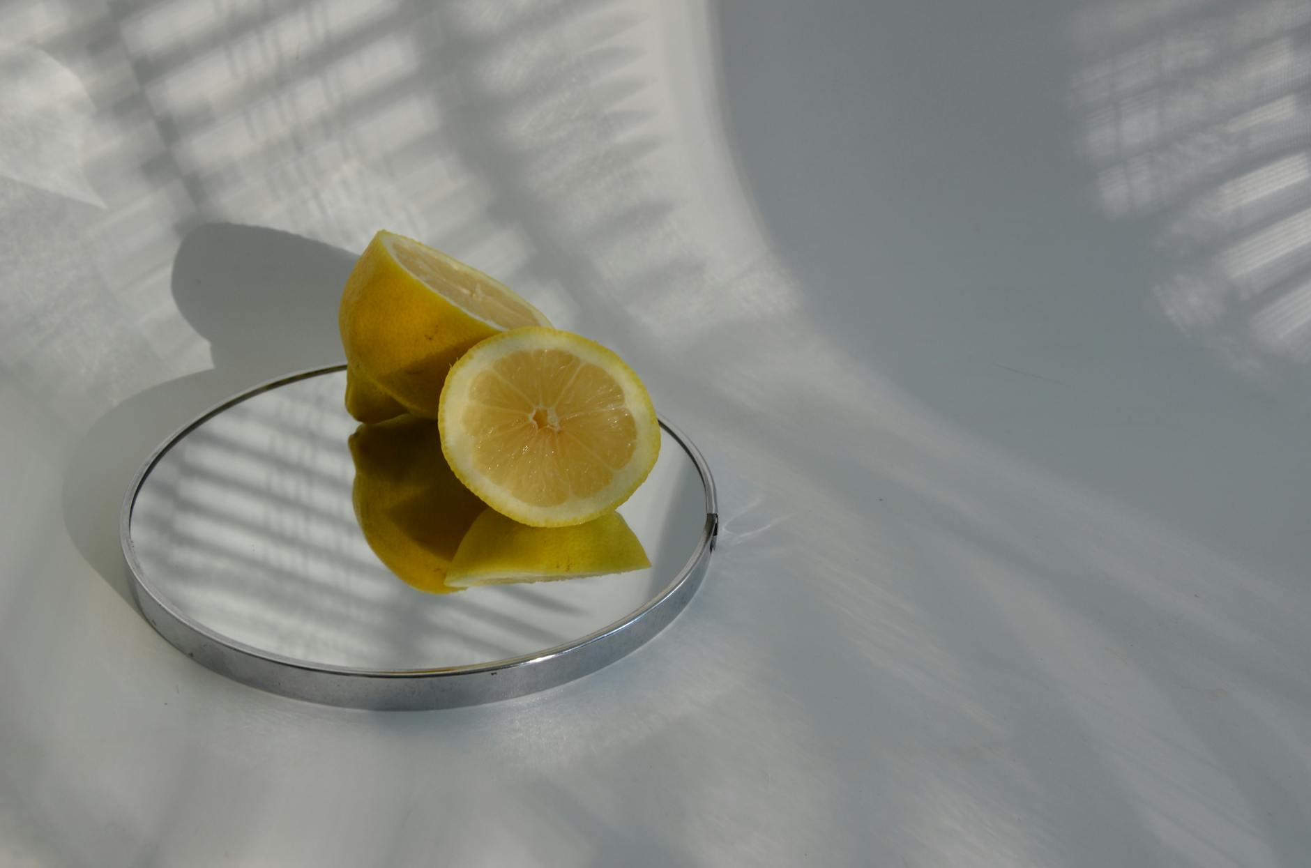 Sliced lemons on a reflective surface, symbolizing clarity and freshness after 50