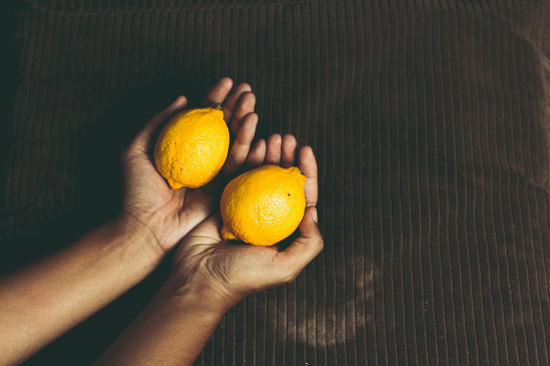 Two fresh lemons held in cupped hands, symbolizing the gentle restoration of sensitivity