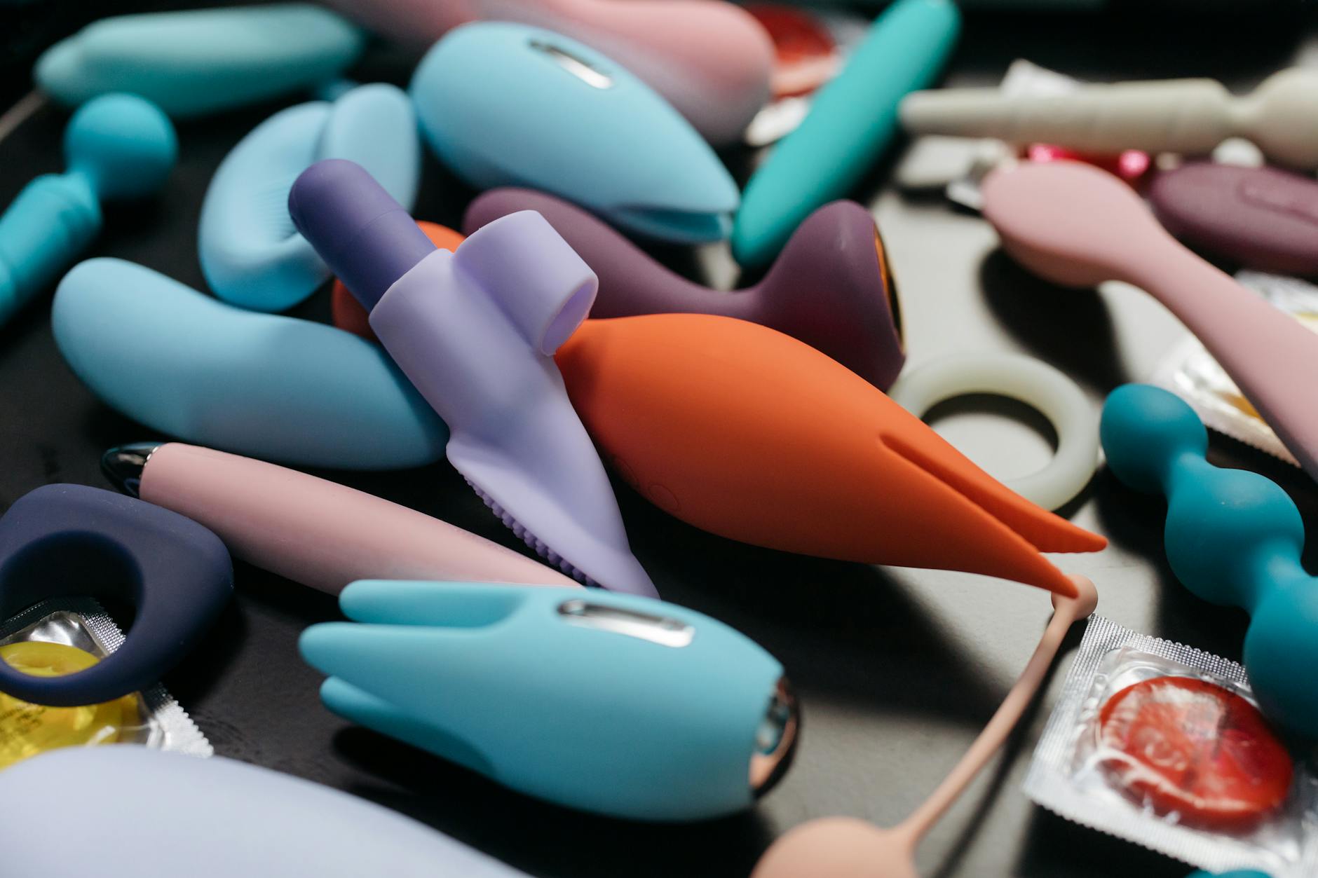 A blue silicone vibrator held in hand against a solid purple background, promoting self-love and sexuality.