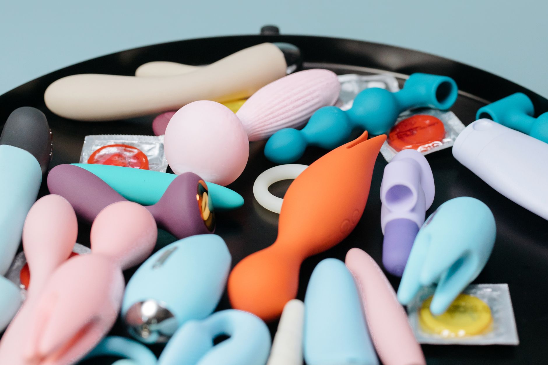 Person holding a blue and pink vibrator, considering sensual recovery options